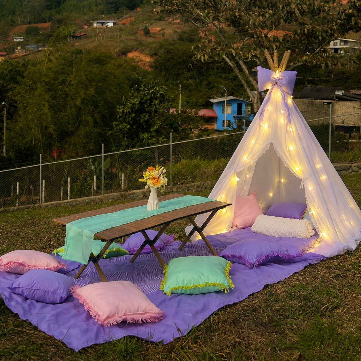 Picnic Cony Decora al atardecer, con teepee iluminado, cojines pastel y mesa decorada, en las montañas de Yumbo