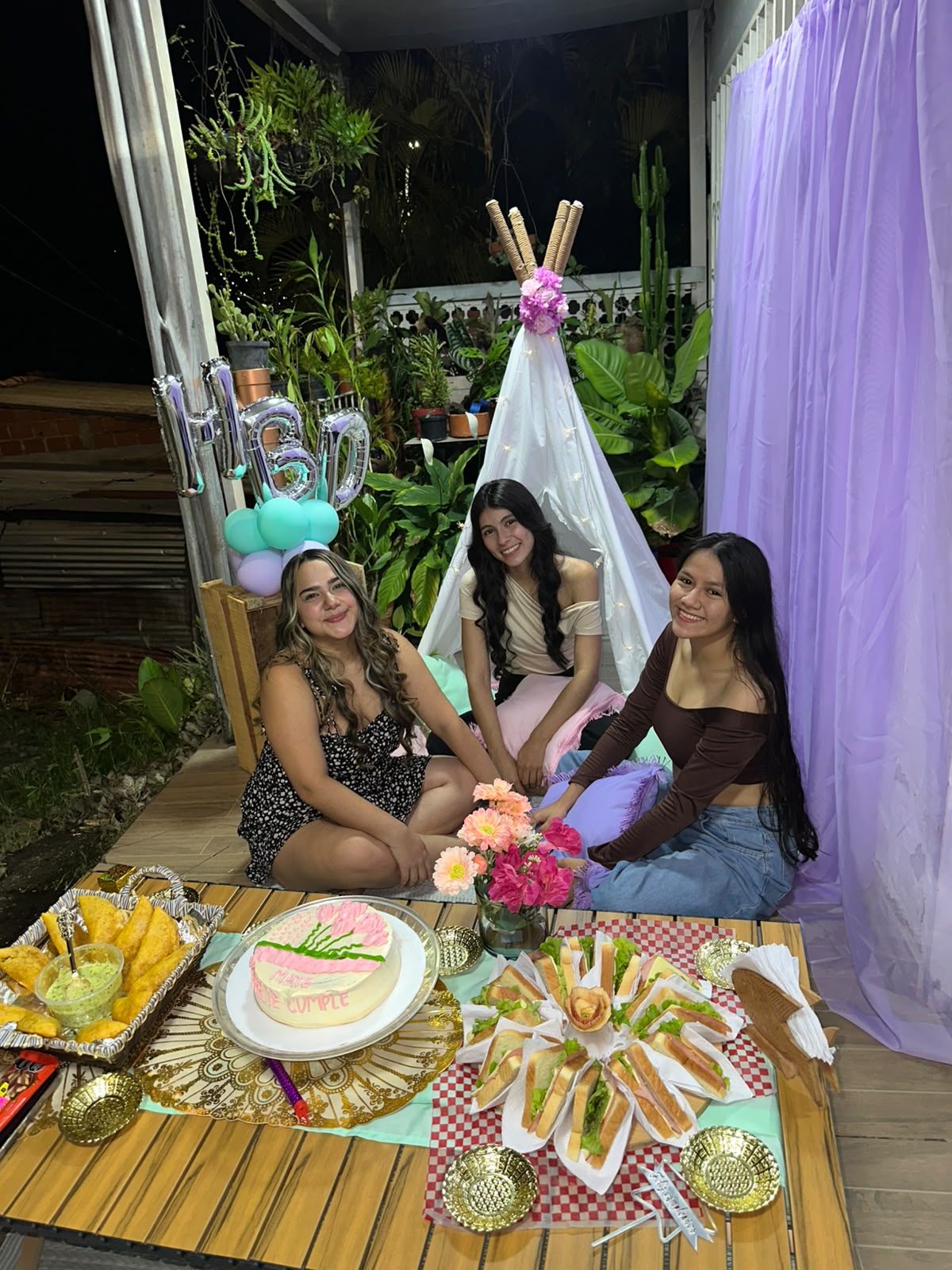Pijamada de cumpleaños entre amigas con teepee, cortina morada y mesa de dulces, montada por Cony Decora